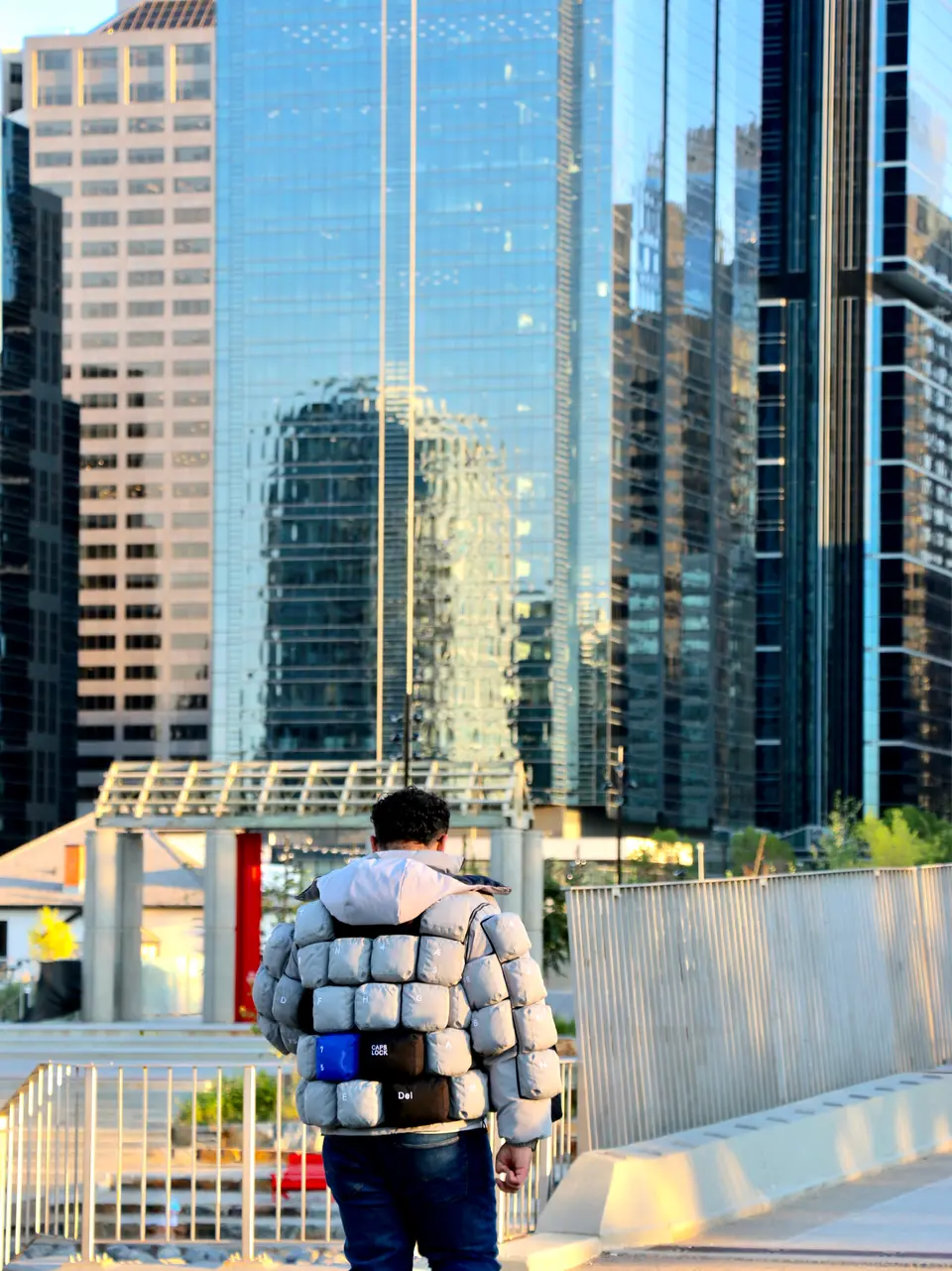 Walking toward a glass office tower.