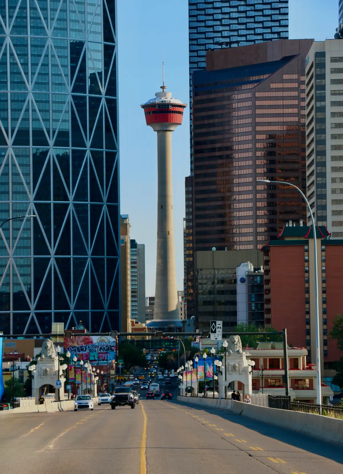 The Centre Street road draws the eye toward Calgary Tower between downtown buildings.
